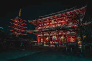 a tall building with red lights in front of it